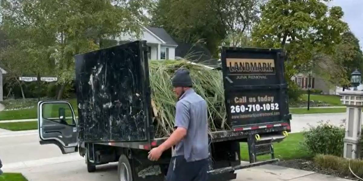 landmark junk removal expert hauling yard debris into truck